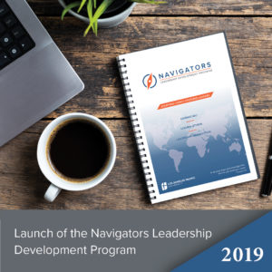 Laptop on desk with Navigators Leadership Program book